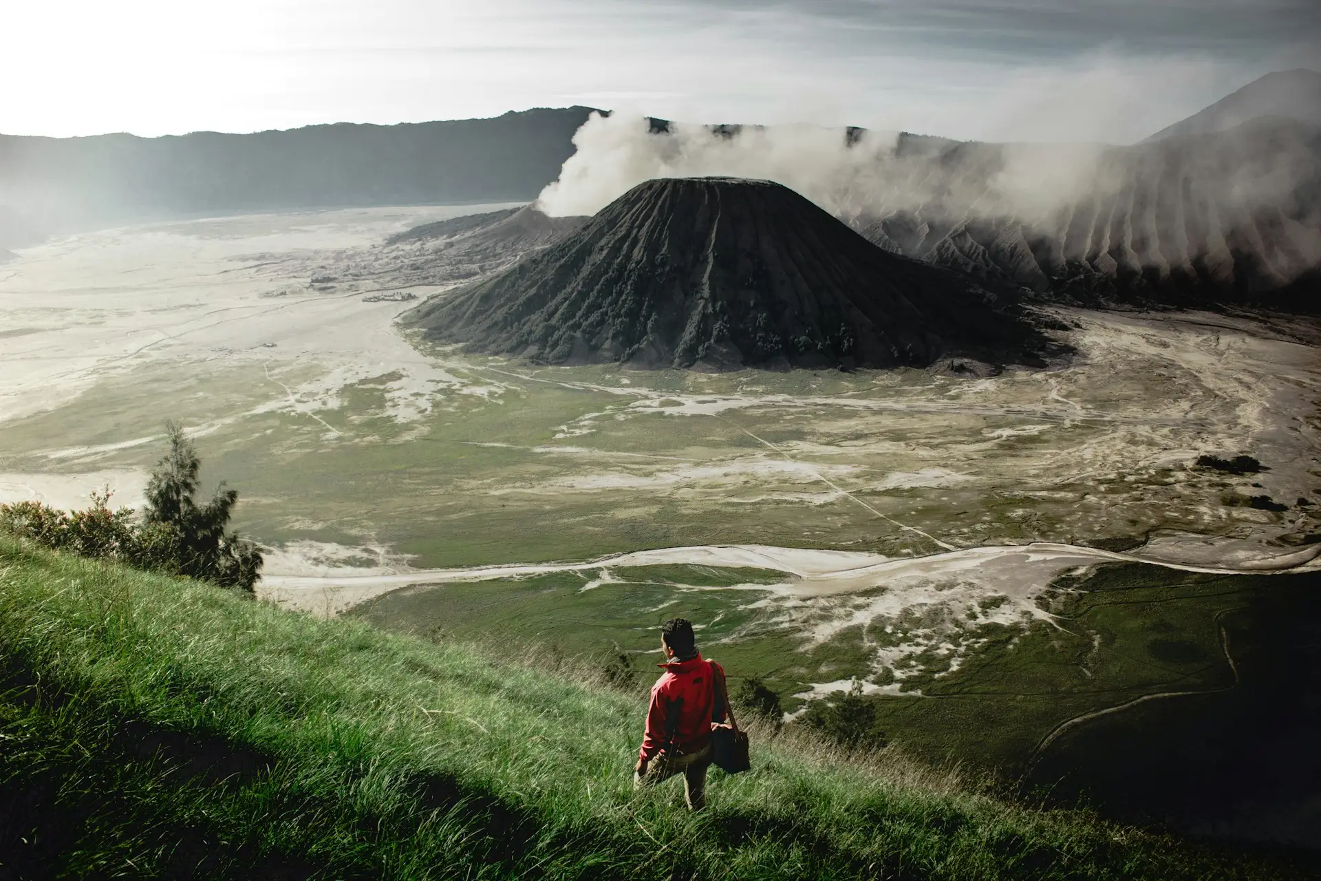Contact Armela Corbaxhi Traveller looking out over a volcanic landscape at sunrise